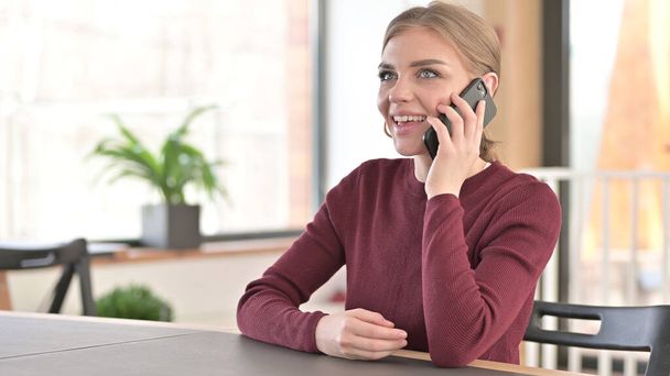 Giovane donna che parla su smartphone in ufficio - Foto, immagini