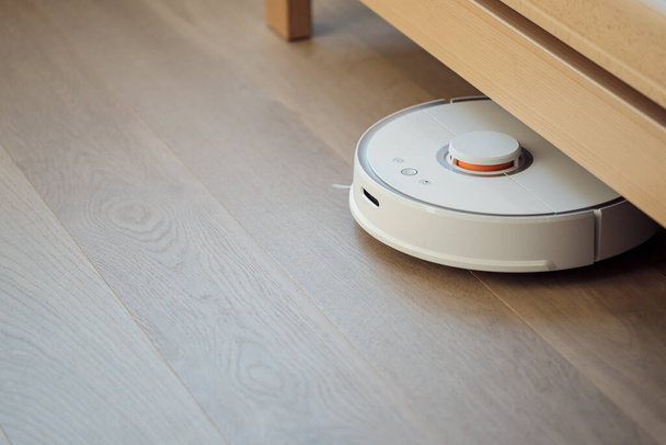 Робот пылесос выполняет автоматическую очистку квартиры умный дом - Фото, изображение