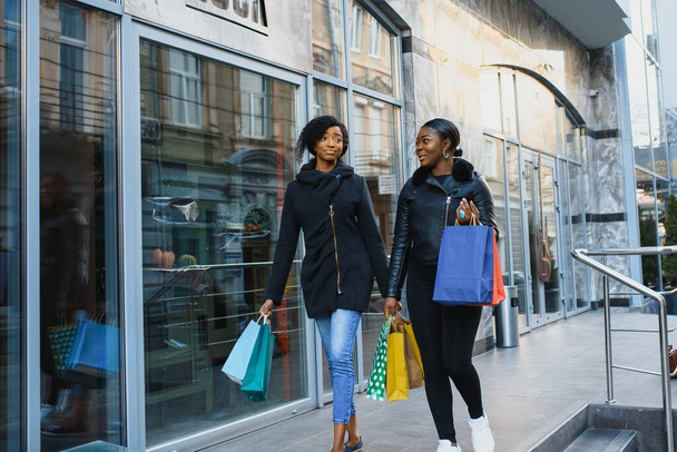 young black women going shopping. African American girls with shopping bags go shopping - Foto, Imagen