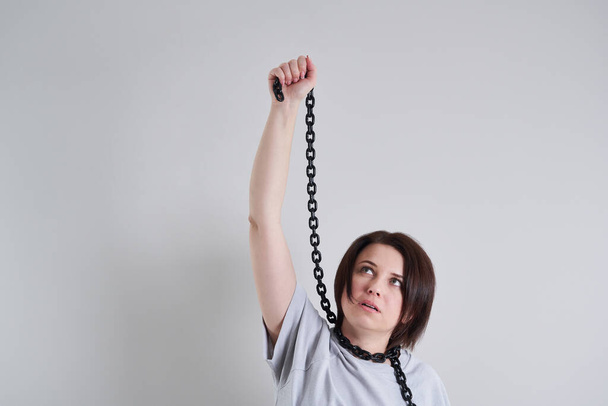Suizidpräventionskonzept: Depressive junge Frau hält Metallkette um den Hals - Foto, Bild