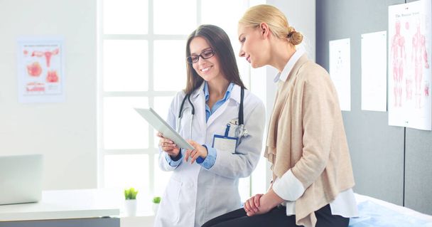 Doctor and patient discussing something while sitting at the table . Medicine and health care concept - Photo, image