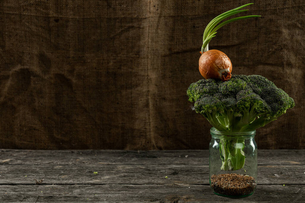 Foto di un grano saraceno e broccoli verdi freschi in vaso, cipolla verde sui broccoli in piedi sul tavolo di legno con copyspace
 - Foto, immagini