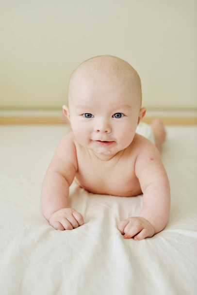 happy baby laying on the big bed - Foto, Imagem
