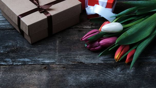 Bouquet of colorful tulips and gift box on vintage wooden background with copy space - Fotografie, Obrázek