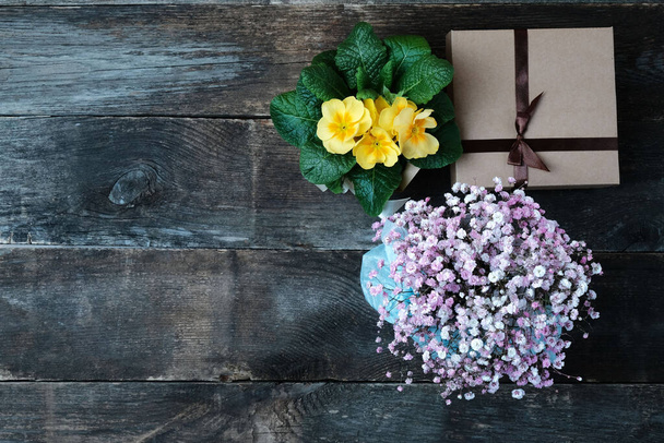Gift cardboard box and a bouquet of flowers on an old vintage wooden background, with copy space. - Fotografie, Obrázek