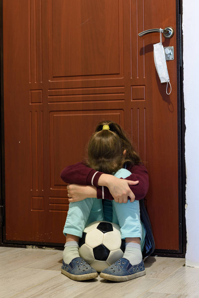 Mädchen in Quarantäne wird gefoltert, wenn sie mit Ball vor der Haustür sitzt - Foto, Bild
