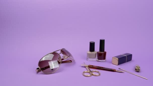 Accessoires pour femmes et accessoires pour ongles sur fond violet
. - Séquence, vidéo