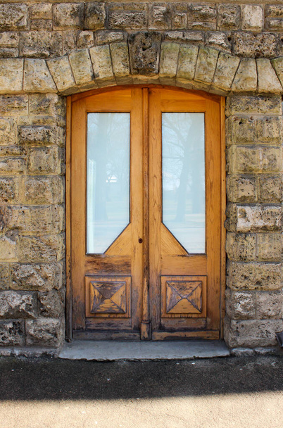 Старые деревянные двойные двери со стеклянными вставками. Старый, но очаровательный фасад здания с дверным проемом
.  - Фото, изображение
