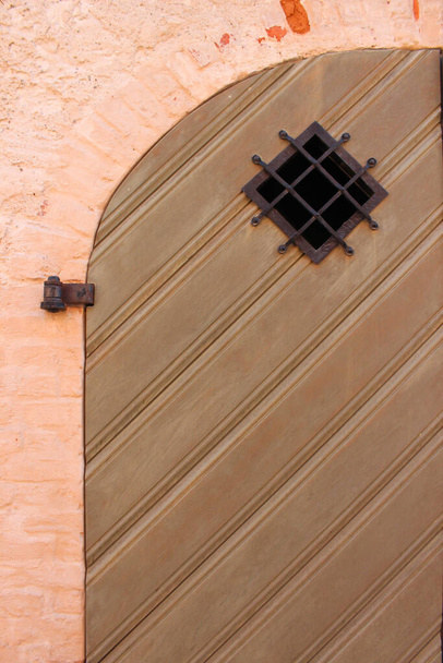 Porte grange en bois avec coin arrondi. Porte de planche en bois avec pièces métalliques forgées
.  - Photo, image