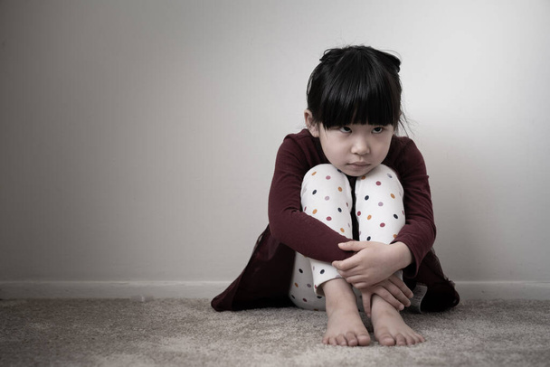 eenzaam verdrietig klein meisje houden haar knieën - Foto, afbeelding