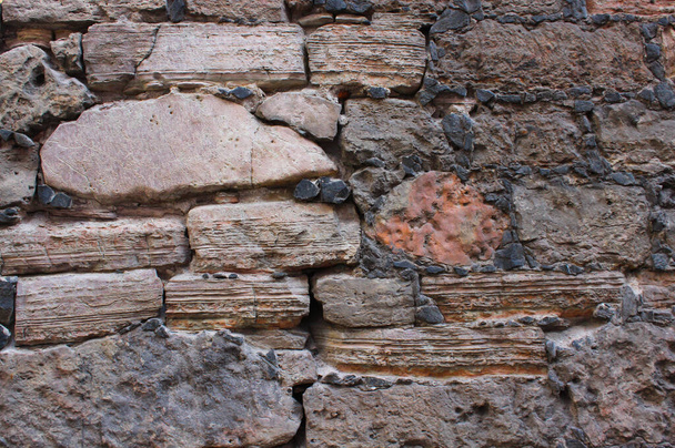 岩で作られた古い壁。中世の岩肌。セメントで固定された古い岩の質感.  - 写真・画像