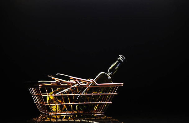 cesta de metal con botellas de alcohol y para la tienda sobre un fondo oscuro con reflejo
 - Foto, Imagen
