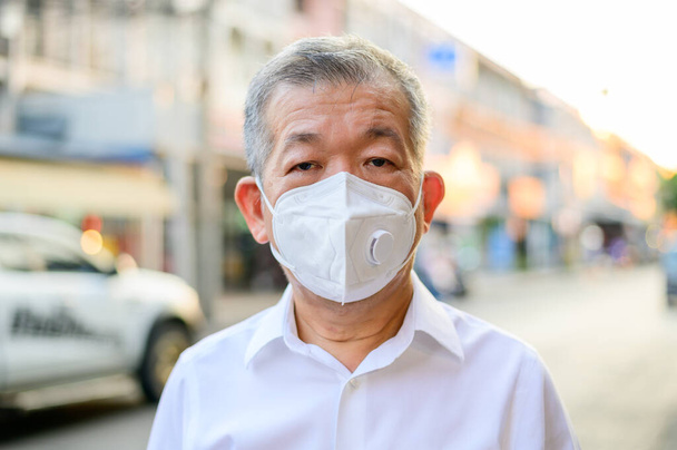 Retrato de un hombre mayor con máscara protectora N95 en la ciudad de la calle
 - Foto, imagen