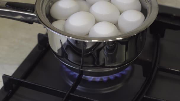Λευκά αυγά κοτόπουλου βρασμένα σε μεταλλικό τηγάνι σε φούρνο γκαζιού. Πρωινό μαγείρεμα - Πλάνα, βίντεο