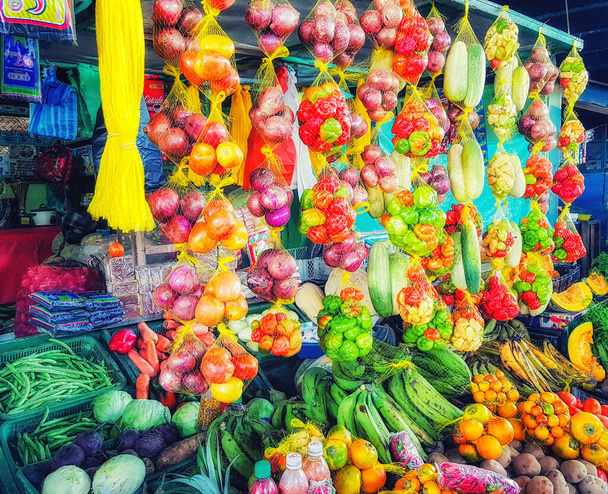Frutas saborosas, frescas e coloridas penduradas em uma tenda de mercado em uma pequena cidade
. - Foto, Imagem