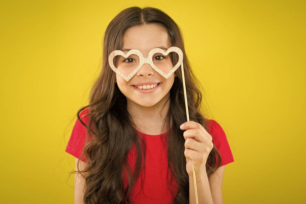 small girl with party glasses. small girl hold funny glasses. happy birthday. party elements. child ready for party. prepare for party. happy girl on yellow background. summer fashion. holiday object - Valokuva, kuva