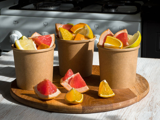 Citrus slices in a environmental paper cups. Vitamin C drink. Strengthening the immune system concept - Photo, Image
