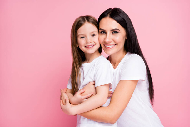 Close-up portrait of two nice attractive lovely adorable perfect ideal sweet cute careful cheerful adopted foster long-haired sister cuddling embracing upbringing isolated pink pastel color background - Fotó, kép
