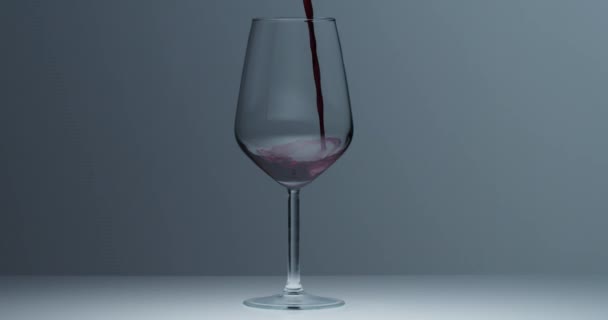 nalewanie czerwonego wina do kieliszka do wina. zwolniony ruch 4k - Materiał filmowy, wideo