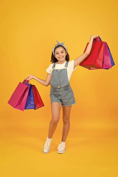 Successful deal. Hurry up. Buy it faster. Happy girl with shopping bags. Little child smile with paper bags. Holidays preparation and celebration. Shopping on black friday. Inspiring shopping - Photo, Image