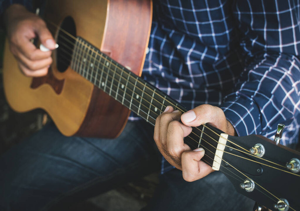 close-up man hand spelen gitaar - Foto, afbeelding
