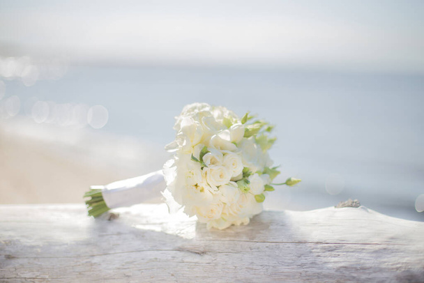 Όμορφο λευκό νυφικό μπουκέτο δίπλα στη θάλασσα   - Φωτογραφία, εικόνα
