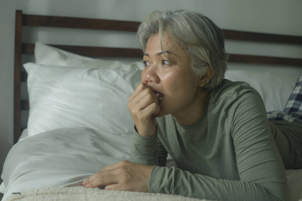 mature lady crisis - indoors lifestyle portrait of middle aged woman with grey hair sad and depressed in bed feeling frustrated and lonely thinking about aging lonely suffering depression  - Photo, Image