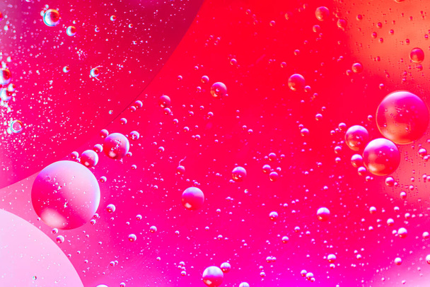 Αφηρημένο πολύχρωμο φόντο με σταγόνες λαδιού και κύματα στην επιφάνεια του νερού. Αφηρημένη έννοια - Φωτογραφία, εικόνα