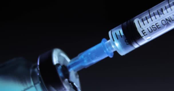 Dials blue medicament coronavirus vaccine into syringe, COVID-19 pandemic. - Video, Çekim
