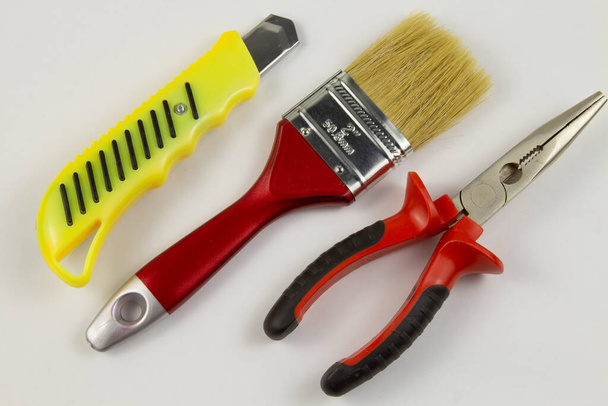 pliers knife brush on a white background, work tools. - Valokuva, kuva