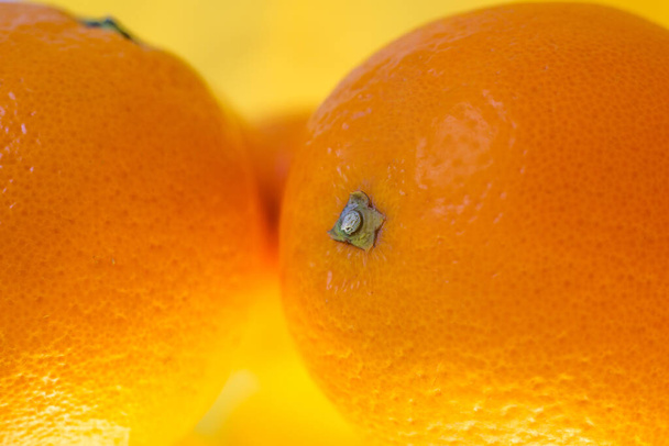 Fruta naranja fresca aislada sobre fondo amarillo. Primer plano de cáscara de naranja fresca sobre fondo amarillo. Bio y alimentos saludables
. - Foto, imagen
