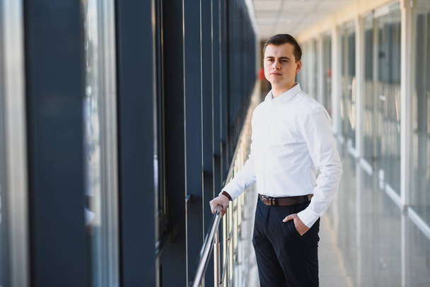 Handsome young businessman near window in office - Fotoğraf, Görsel