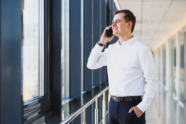 Handsome young businessman near window in office - Photo, Image