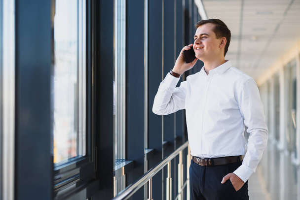 Handsome young businessman near window in office - Photo, image