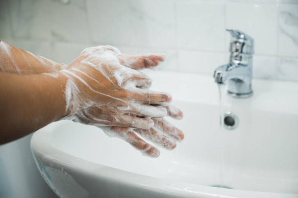 Cerrar Manos masculinas lavándose las manos con jabón. para la prevención del virus corona
. - Foto, imagen