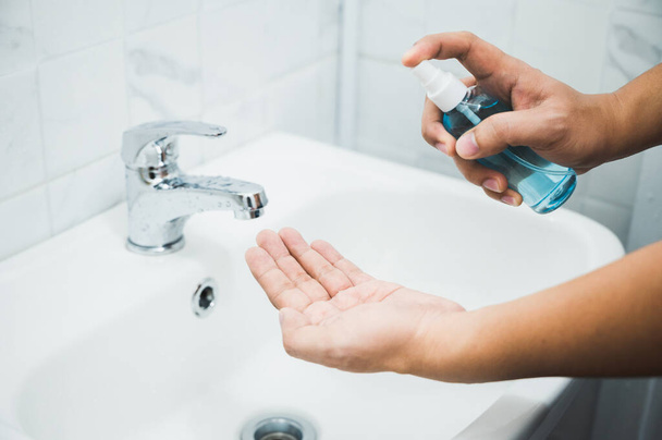 Zamknąć męskie ręce Coronavirus zapobieganie jego ręka z dezynfektorem alkoholu spray dla higieny rąk Corona ochrony wirusów w łaźni. - Zdjęcie, obraz