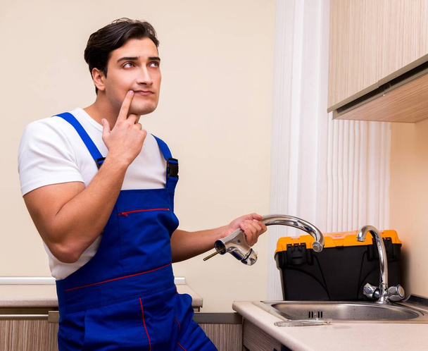 Junger Reparateur arbeitet in der Küche - Foto, Bild