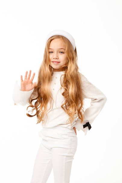 tyttö pitkät hiukset, pukeutunut valkoisiin vaatteisiin, seisoo valkoisella taustalla
 - Valokuva, kuva