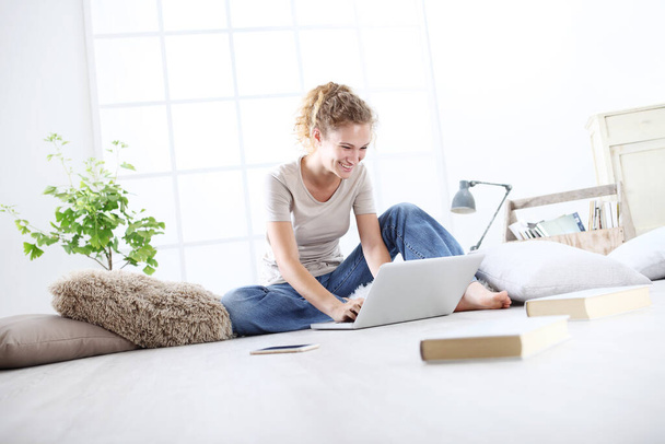 jeune femme assise dans le salon à l'ordinateur, rester à la maison concept
 - Photo, image
