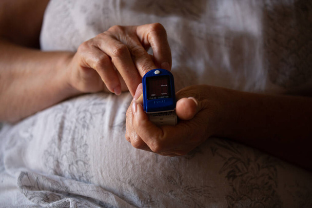 Pulse Oximeter On a female finger. Woman using Oximeter. Healthy Concept. Due Coronavirus medical equipment. - Фото, зображення