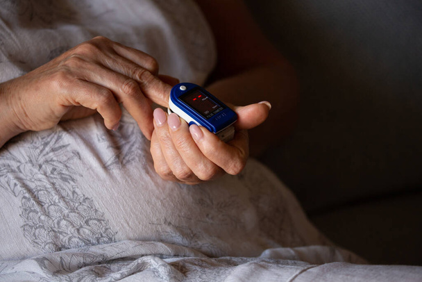 Pulse Oximeter On a female finger. Woman using Oximeter. Healthy Concept. Due Coronavirus medical equipment. - Zdjęcie, obraz