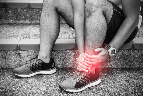 Gebrochener Knöchel. Läufer berührt Fuß vor Schmerzen wegen verstauchtem Knöchel - Foto, Bild