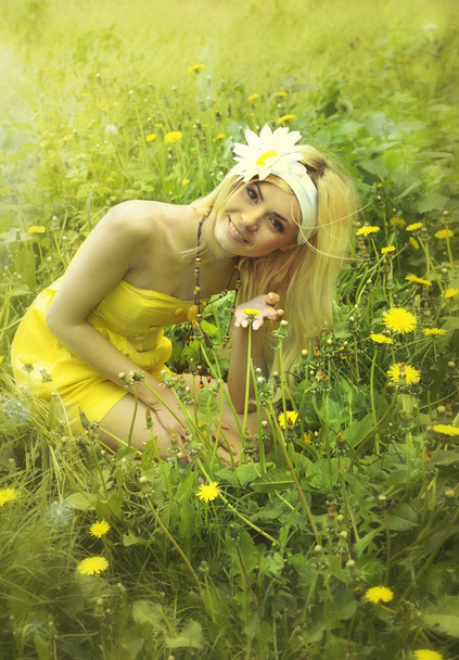 çimenlerin üzerinde oturan sarı elbiseli güzel kadın. - Fotoğraf, Görsel
