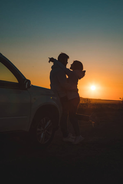 romantyczny moment para całowanie na zachód słońca w pobliżu biały suv samochód kopia miejsca. - Zdjęcie, obraz