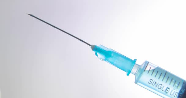 Syringe with blue vaccine against coronavirus, sars, flu on light background. - 映像、動画