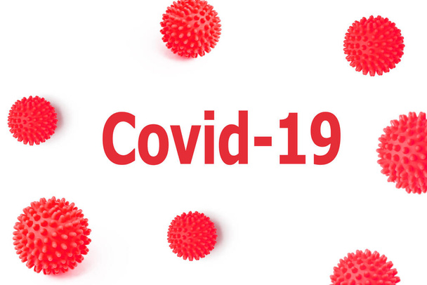 L'inscription Covid-19 Coronavirus sur un fond blanc isolé avec des boules rouges tachetées représentant les bactéries du virus mortel Ncov
. - Photo, image