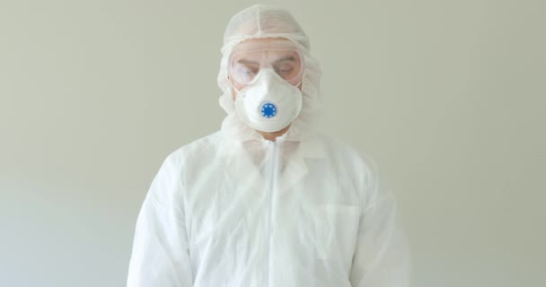 Доктор в защитном костюме держит хэштег остаться дома в пандемии коронавируса
. - Кадры, видео