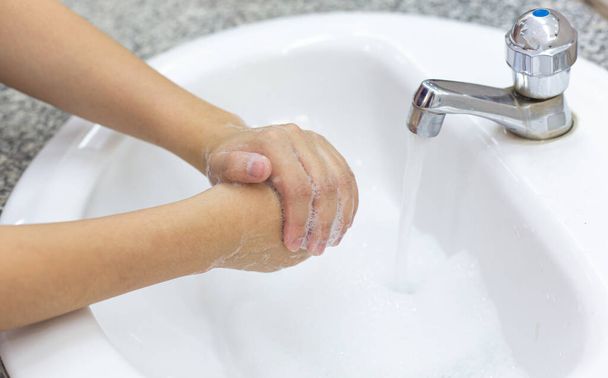 Νεαρές γυναίκες πλένουν τα χέρια τους με σαπούνι για την πρόληψη βακτηριακών και ιογενών λοιμώξεων Corona ή Covid-19, Εμποδίζοντας την εξάπλωση και την προστασία της έννοιας του ιού - Φωτογραφία, εικόνα
