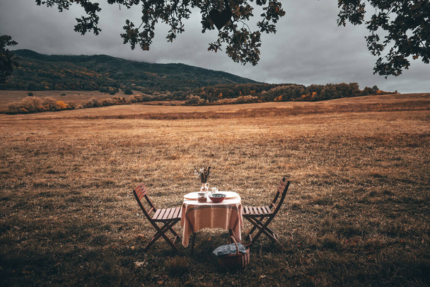 Table is set and waiting for dining in the countryside. Vintage color tone - Fotó, kép