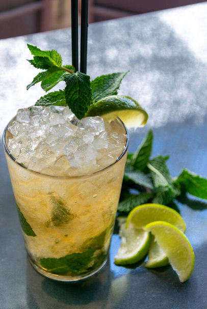 a chilled lime and mint Mojito cocktail drink with some ingredients alongside  - Foto, Imagem